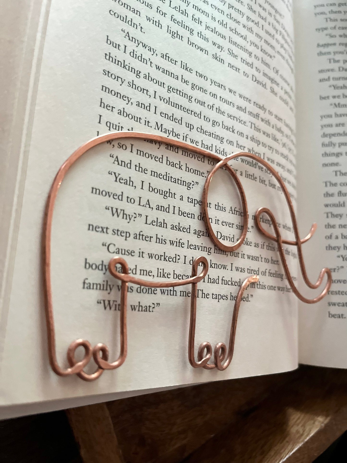 The bookmark is made of a single piece of wire that is bent into the shape of an elephant. The elephant has a long trunk, large ears, and a small tail.
